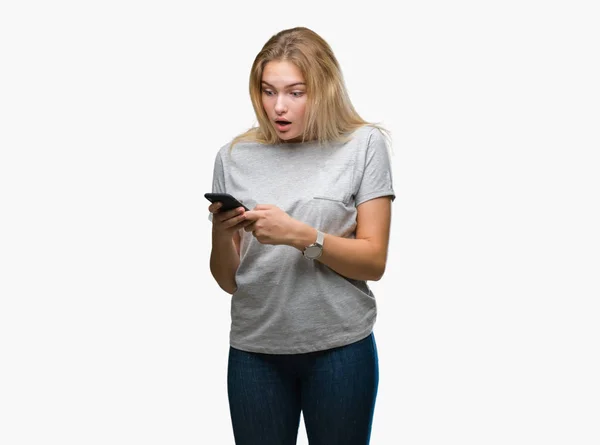 年轻的高加索妇女发送消息使用智能手机在孤立的背景吓得惊心动魄的一张惊喜的脸 害怕和兴奋的恐惧表情 — 图库照片