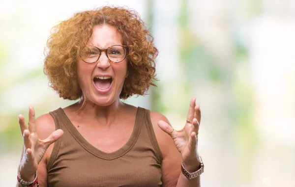 中年のヒスパニック系女性で眼鏡をかけて背景クレイジーを分離し 怒って叫んで 叫んで積極的な表現と腕を上げます 欲求不満のコンセプト — ストック写真