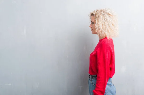 Mladá Blondýnka Kudrnatými Vlasy Nad Grunge Šedé Pozadí Pohledu Stranu — Stock fotografie