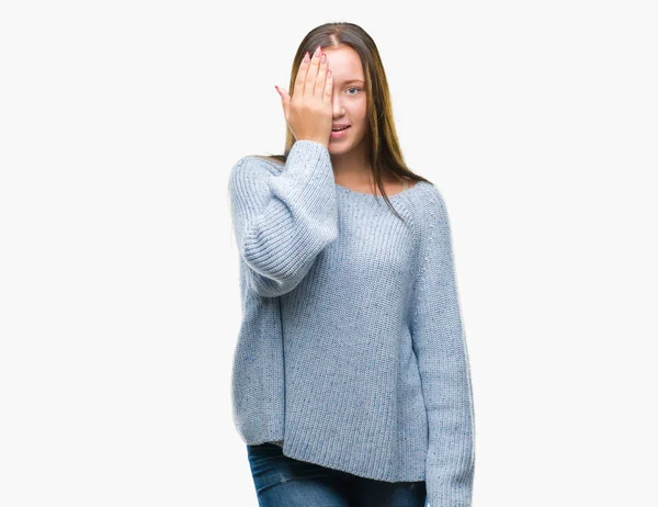 年轻美丽的白人妇女穿着冬季毛衣在孤立的背景覆盖一只眼睛与手与自信的微笑在脸上和惊喜的情绪 — 图库照片