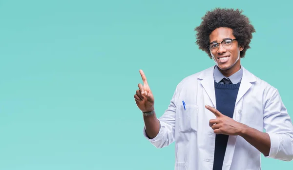 非裔美国医生科学家男子在孤立的背景微笑 看着相机指向用两只手和手指的一侧 — 图库照片