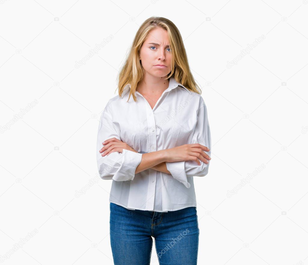 Beautiful young business woman over isolated background skeptic and nervous, disapproving expression on face with crossed arms. Negative person.