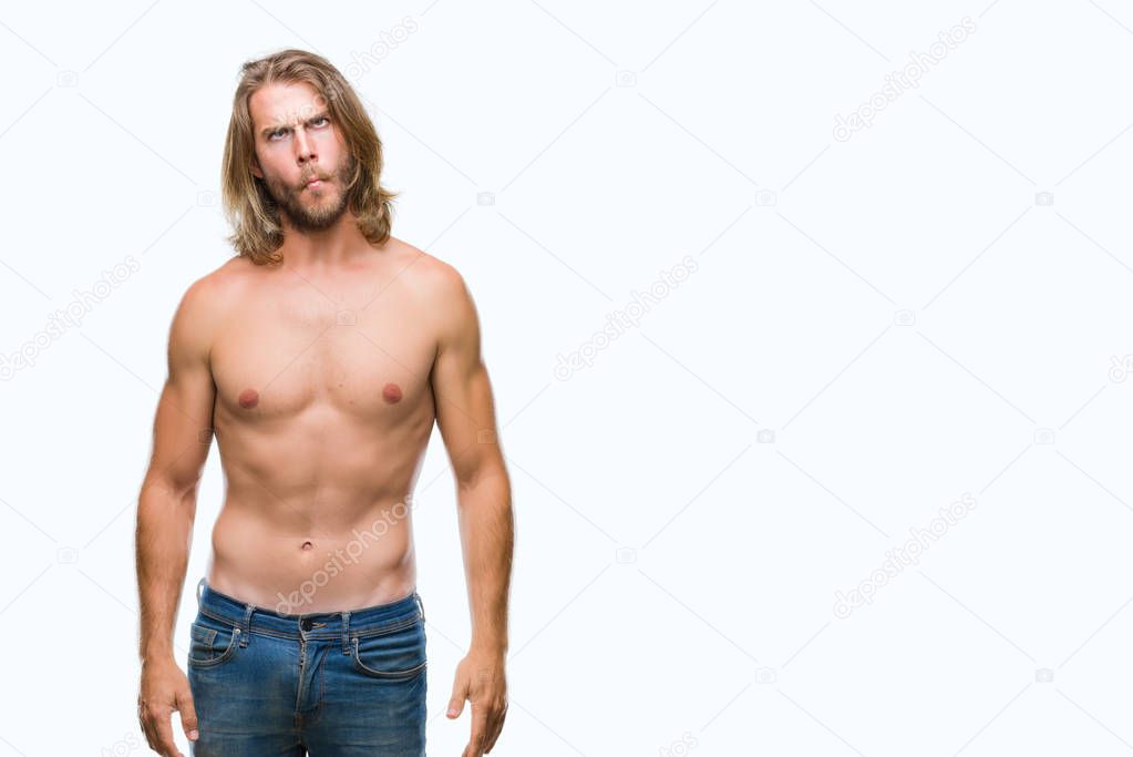 Young handsome shirtless man with long hair showing sexy body over isolated background making fish face with lips, crazy and comical gesture. Funny expression.