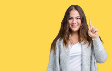 Artı boyutu genç kadın güzel kış ceket üzerinde gösterilen ve parmak gülümseyen süre bir numara ile kendinden emin ve mutlu yukarıyı arka plan izole.