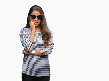 Tırnak ısırma dudaklarından eller genç güzel Arap kadın stresli ve gergin ile izole arka plan üzerinde güneş gözlüğü takıyor. Anksiyete sorunu.