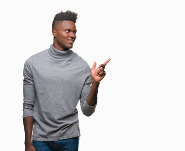 Kameraya bakarak yan el ve parmak ile işaret eden genç Afro-Amerikan adam yüzünde kocaman bir gülümseme ile izole arka plan üzerinde.