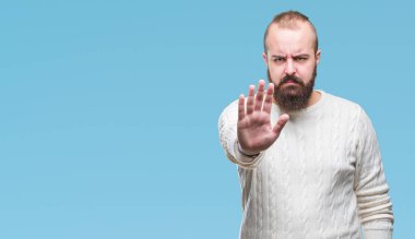Genç beyaz hipster adam giyen kış kazak stop yapıyor izole arka plan üzerinde şarkı elin avuç ile. Negatif ve ciddi bir jest yüz ifadesiyle uyarı.