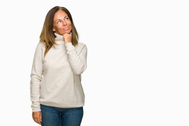 Üzerinde kış kazak giyen güzel orta yaş yetişkin kadın arka plan çene düşünme hakkında soru, dalgın ifade üzerine el ile izole. Düşünceli yüzüyle gülümsüyor. Şüphe kavramı.