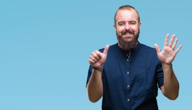 Gösterilen ve parmakları ile işaret izole arka plan Genç beyaz hipster adam kendinden emin ve mutlu gülümseyerek süre 6 numara.