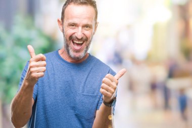 Orta yaş ağarmış komuta sizde izole arka plan başarı işareti el ile pozitif jest yapıyor üzerinde başparmak gülümseyen ve mutlu. Neşeli bir ifadeyle, kazanan jest kameraya bakıyor.