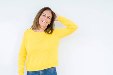 Çekici poz arka plan Gülen hareketi, el emin dokunaklı saç üzerinde sarı kazak giyen güzel orta yaş kadın izole