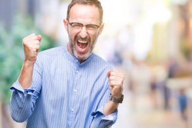 Gülümseyen ve başarı için çığlık izole arka plan çok mutlu ve heyecanlı kaldırdı, silah ile kazanan jest yapıyor üzerinde gözlük takan orta yaş ağarmış komuta sizde. Kutlama kavramı.