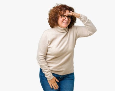 Güzel orta ager kadın kıdemli giyen boğazlı kazak ve izole arka plan çok mutlu ve gülümseyen uzakta ile seyir üzerinde gözlük over head el. Arama kavramı.