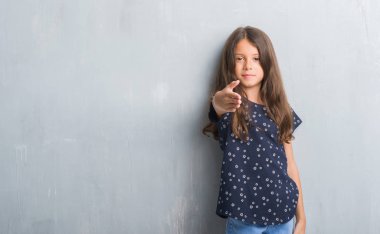 Grunge gri duvar dostu sunan el sıkışma tebrik ve davet edici olarak gülümseyen genç İspanyol çocuk. Başarılı iş.