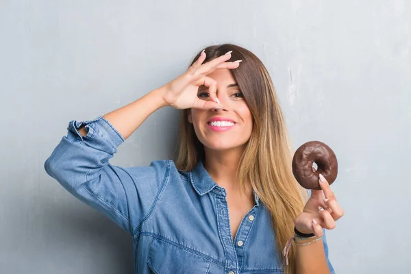 Ung Vuxen Kvinna Över Grå Grunge Vägg Äta Choklad Donut — Stockfoto