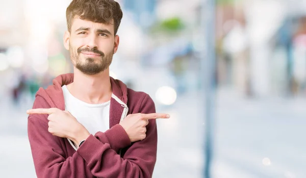 Jeune Homme Beau Sur Fond Isolé Pointant Des Deux Côtés — Photo