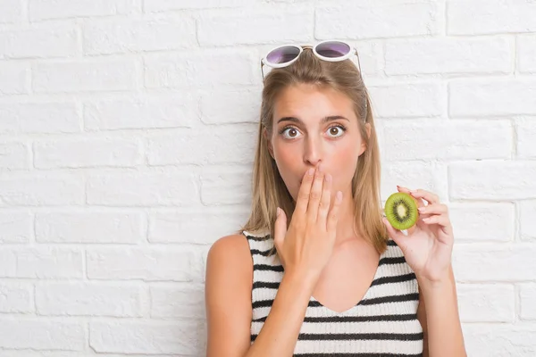 Hermosa Mujer Joven Sobre Pared Ladrillo Blanco Comiendo Boca Cubierta — Foto de Stock