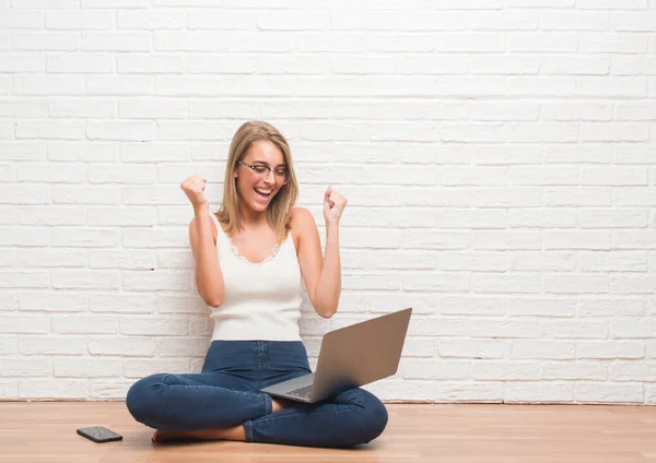 Hermosa Joven Sentada Suelo Trabajando Usando Portátil Casa Gritando Orgullosa —  Fotos de Stock