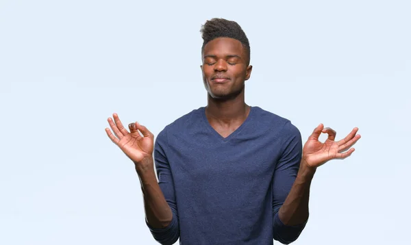在孤立的背景下 年轻的非洲裔美国人放松和微笑闭上眼睛做冥想手势用手指 瑜伽理念 — 图库照片