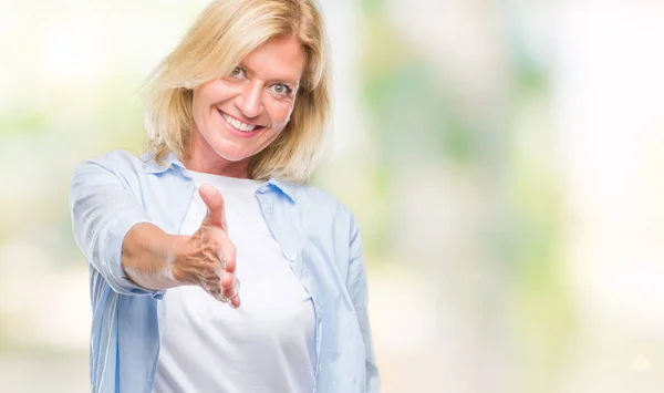中年金发女人在孤立的背景微笑友好提供握手作为问候和欢迎 成功的企业 — 图库照片