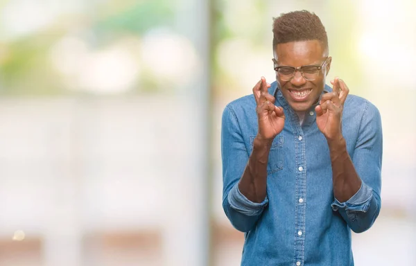 Joven Afroamericano Sobre Fondo Aislado Sonriendo Cruzando Los Dedos Con — Foto de Stock