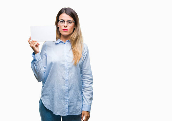 Young beautiful business woman holding blank card over isolated background with a confident expression on smart face thinking serious