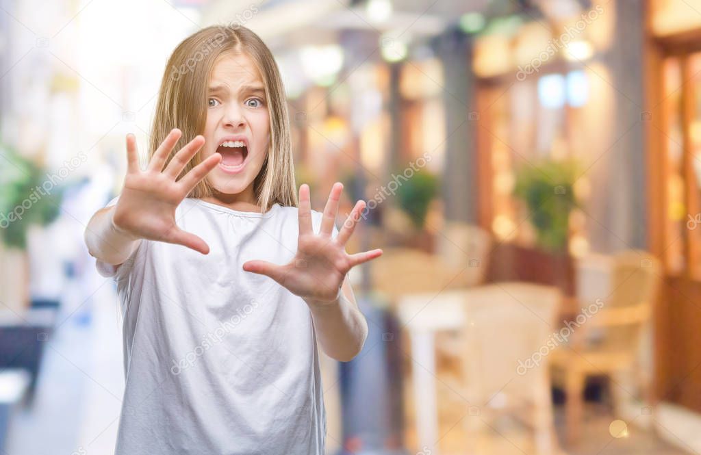 Young beautiful girl over isolated background afraid and terrified with fear expression stop gesture with hands, shouting in shock. Panic concept.