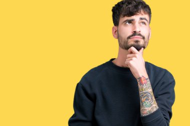 Yakışıklı delikanlı çene düşünme hakkında soru, dalgın ifade üzerine el ile izole arka plan üzerinde. Düşünceli yüzüyle gülümsüyor. Şüphe kavramı.