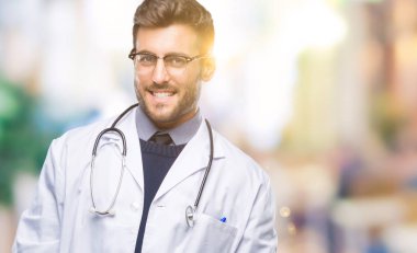 Genç yakışıklı adam uzak tarafına yüzünde, doğal ifade gülümseme ile seyir izole arka plan üzerinde doktor. Kendine güvenen gülüyor.