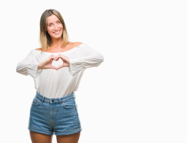 Genç güzel kadın kalp simgesi ve elleriyle şekil gösterilen aşık gülümseyen izole arka plan yüzünden. Romantik kavramı.