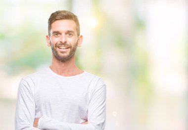 İzole arka plan mutlu yüz çapraz silah kameraya bakarak ile gülümseyen genç yakışıklı adam. Olumlu bir kişi.