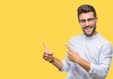 Yakışıklı delikanlı gülümseyen ve iki elleri ve parmakları ile tarafına işaret kamera bakarak izole arka plan üzerinde.