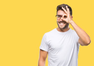 Gülümseyen, parmakları ile mutlu yüz üzerinden seyir göz el ile ok jest yapıyor izole arka plan üzerinde gözlük takan genç yakışıklı adam.