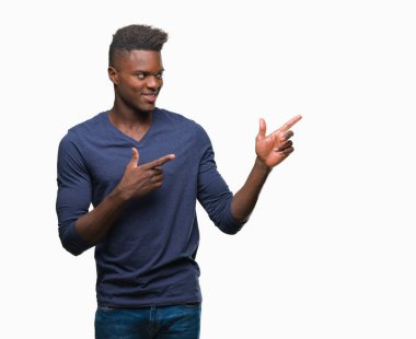 Gülümseyen ve iki elleri ve parmakları ile tarafına işaret kamera bakarak izole arka plan üzerinde genç Afro-Amerikan adam.