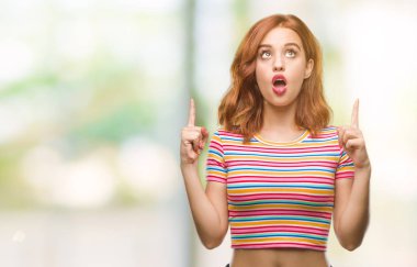 Genç güzel kadın izole arka plan üzerinden hayran ve yukarıya bakıp parmakları ile işaret şaşırttı ve silah kaldırdı.