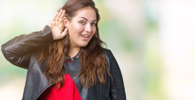 Artı boyutu genç kadın güzel üzerinde bir moda deri ceket giyen bir işitme söylenti ya da dedikodu için dinleme kulak üzerinde el ile gülümseyen arka plan izole. Sağırlık kavramı.