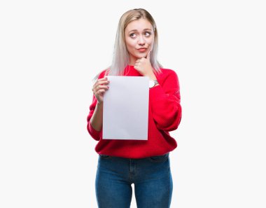 Sarışın genç kadın holding boş kağıt sayfası izole arka plan ciddi bir yüz düşünme hakkında soru, çok karışık bir fikir üzerinde