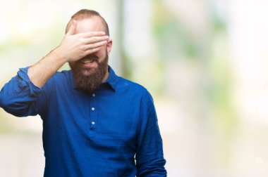 Genç beyaz hipster adam gülümsüyor ve gözleri için sürpriz kapsayan yüz el ile gülüyor izole arka plan üzerinde gözlük takıyorum. Kör kavramı.