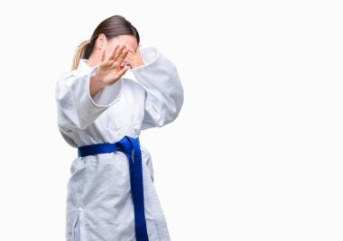 Üzerinde karate kimono üniforma giyen genç güzel kadın gözleri elleriyle kapsayan arka plan izole ve stop jest ile acı ve korku ifadesi. Utandım ve negatif kavramı.