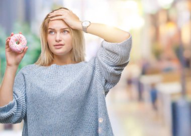 Baş, el ile vurguladı izole arka plan üzerinde tatlı çörek yeme genç kafkas kadın şok utanç ve sürpriz suratla, öfkeli ve sinirli. Korku ve hata için üzgün.