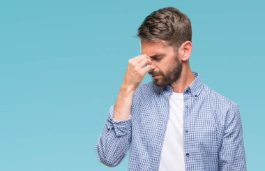 İzole arka plan yorgun sürtünme burun ve göz yorgunluğu ve baş ağrısı duygu üzerinde beyaz t-shirt giyen genç yakışıklı adam. Stres ve hayal kırıklığı kavramı.