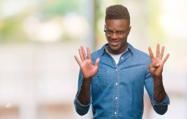 Genç Afro-Amerikan adam gösterilen ve parmakları ile işaret izole arka plan üzerinde numara 9 kendinden emin ve mutlu gülümseyerek süre.
