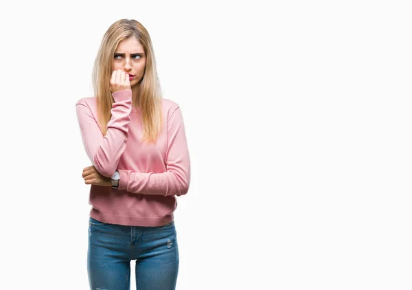 年轻美丽的金发碧眼的女人穿着粉红色的冬季毛衣在孤立的背景看起来紧张和紧张的手在嘴咬指甲 焦虑问题 — 图库照片