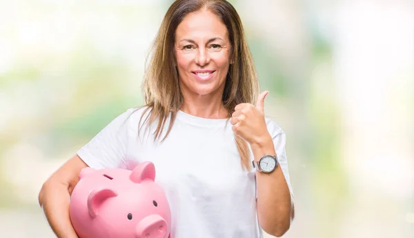 Mulher Hispânica Meia Idade Economizando Dinheiro Usando Mealheiro Sobre Fundo — Fotografia de Stock