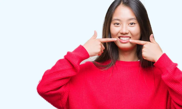 若いアジアの女性は自信を示すと指歯と口を指して笑って孤立の背景に冬のセーターを着ています 健康の概念 — ストック写真