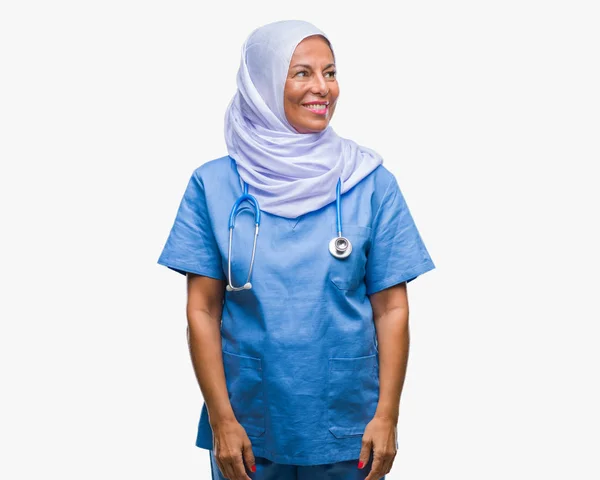 中年シニア アラブでは 自然な表現の顔に笑みを浮かべて側に離れて見て孤立の背景にヒジャーブを着ている女性看護師します 自信を持って笑ってください — ストック写真