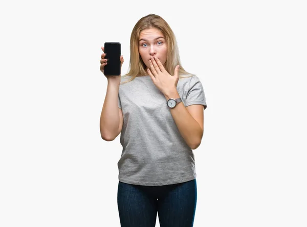 年轻的高加索妇女显示智能手机屏幕在孤立的背景覆盖嘴与手震惊与耻辱 表达恐惧 害怕在沉默中 秘密的概念 — 图库照片