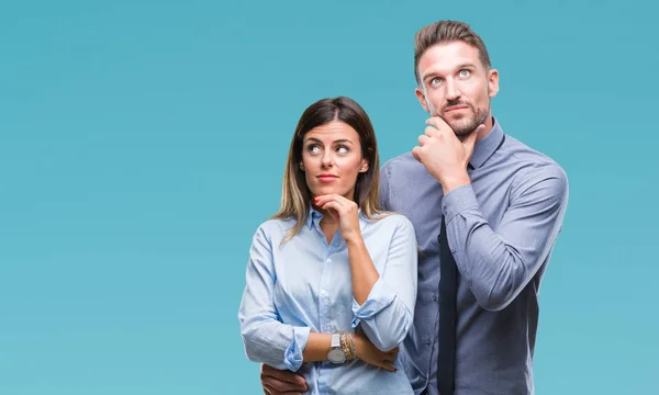 stock image Young workers business couple over isolated background with hand on chin thinking about question, pensive expression. Smiling with thoughtful face. Doubt concept.