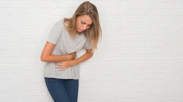 Hermosa Mujer Joven Sobre Pared Ladrillo Blanco Con Mano Estómago — Foto de Stock