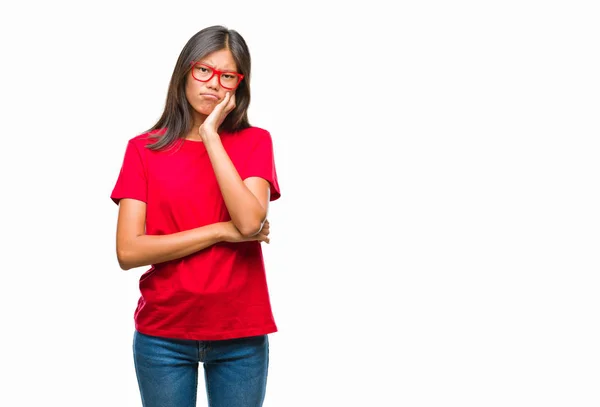 年轻的亚洲妇女戴着眼镜在孤立的背景下思维疲惫和厌倦与交叉手臂的抑郁症问题 — 图库照片